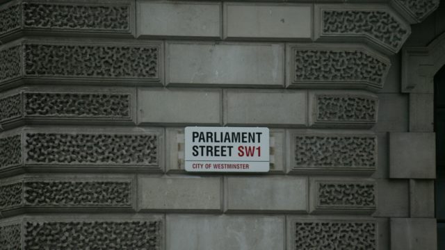 Brick wall and a sign showing Parliament Street SW1