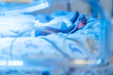 Photo showing baby blanket and tubes in hospital setting